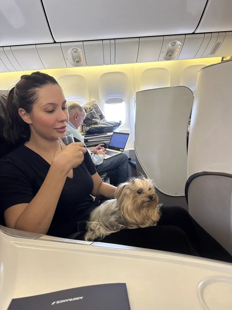 Luanna Lopes, fundadora da Pet Viajante, viajando na cabine do avião com sua cachorra Hope
